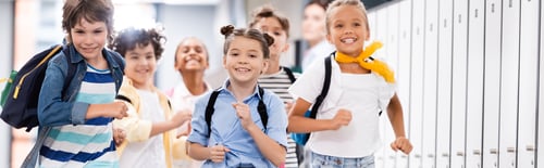 Preview: panoramic shot of excited multicultural schoolkids running along school corridor
