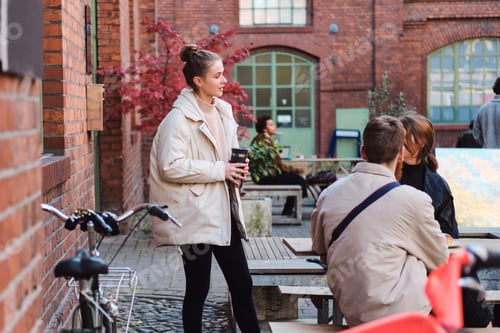 Preview: Group of friends talking and drinking coffee resting together in cafe outdoor