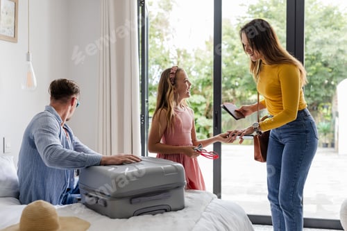 Preview: Family preparing for vacation, packing suitcase and checking smartphone at home