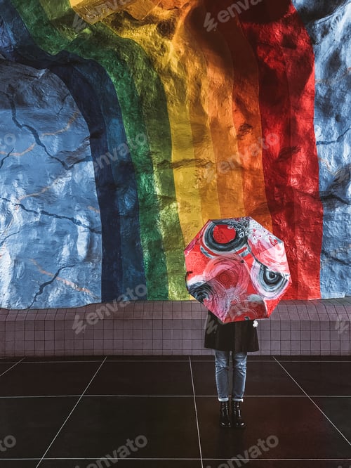 Preview: woman with umbrella on a background of a wall with a rainbow