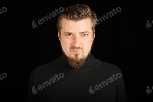 Preview: Tense bearded young guy in black polo neck sweater.