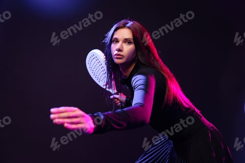 Preview: Female athlete engaged in an action-packed game with a racket indoors