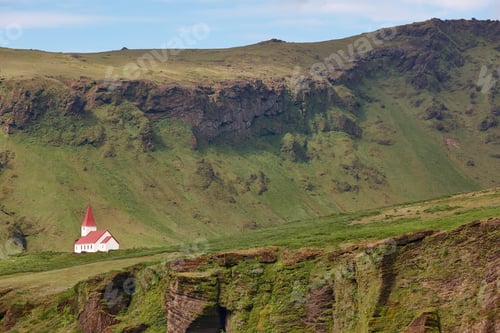 Preview: Traditional chapel with red roof in Vik. Mountain landscape. Iceland