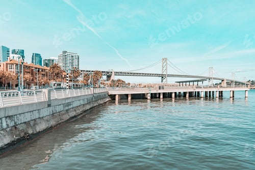 Preview: A bridge spans a body of water, with a city in the background