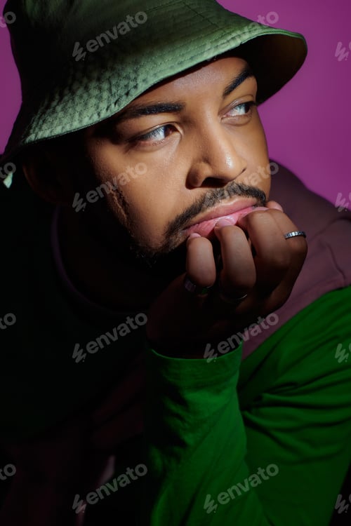 Preview: stylish handsome man in casual trendy outfit putting his face on hand with rings, fashion concept