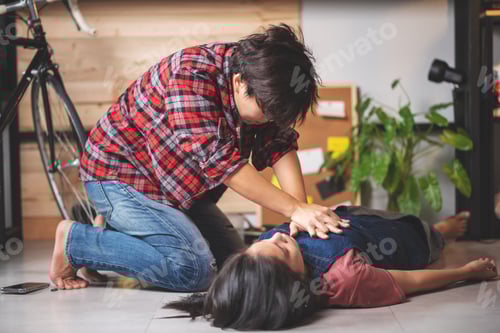 Preview: First aids emergency CPR on heart attack woman laying unconscious in home.