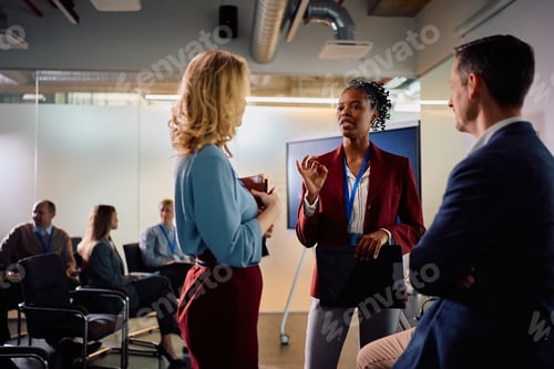 Preview: Multiracial business colleagues talking after a presentation in board room.
