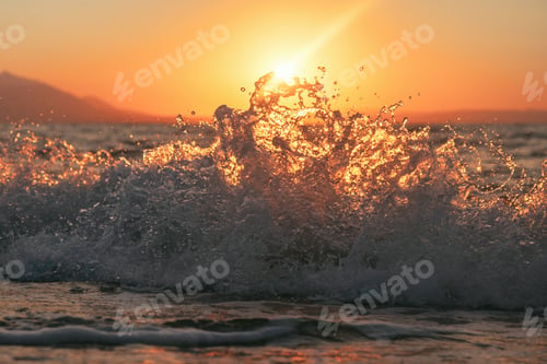 Preview: Ocean wave breaking with a beautiful sunrise in background