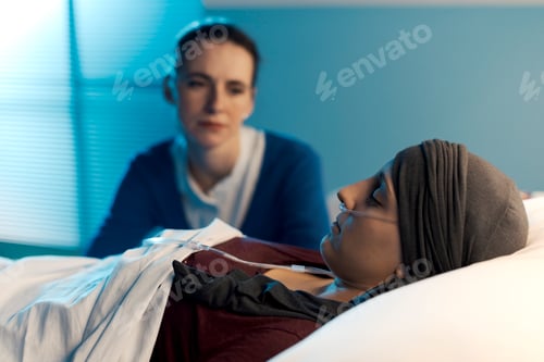 Preview: Caring woman assisting her friend with cancer at hospital