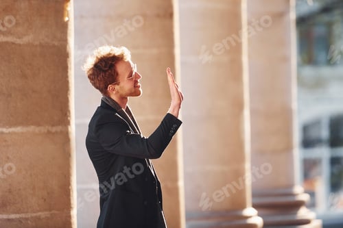Preview: Talking to someone. Elegant young man in formal classy clothes outdoors in the city