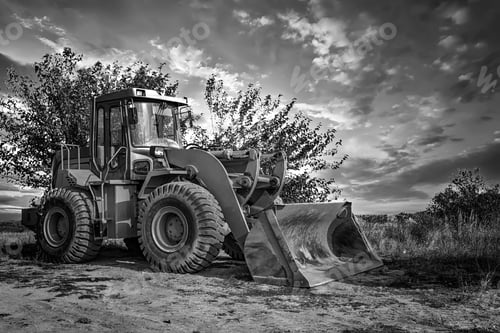 Preview: A bulldozer or loader moves the earth at the construction site against the sky