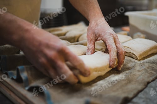 Preview: Baker man placing bread dough on cloth