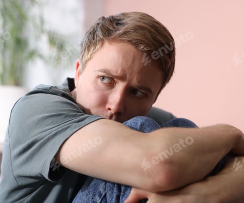 Preview: Scared man suffering from paranoia at home