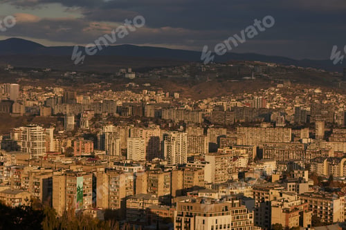 Preview: Scenic view of Tbilisi surrounded by majestic mountains in the distance at sunrise in Georgia