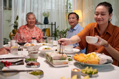 Preview: Woman Taking Spring Roll from Dish
