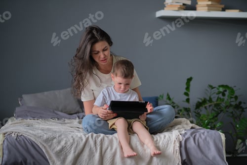 Vorschau: Mutter und Sohn mit Tablet zu Hause. Mutter zeigt ihrem Sohn Medieninhalte online