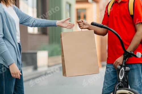 Preview: Male courier with bicycle delivered no name shopping bag to client and food service at home