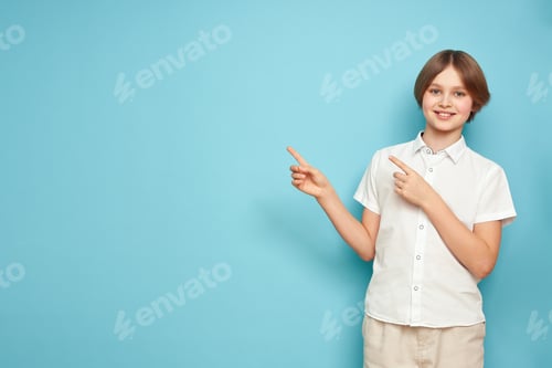 Preview: Young male kid pointing at copy space