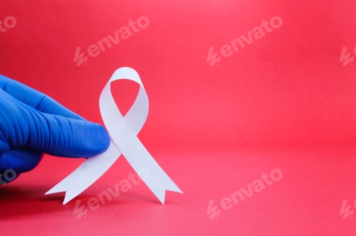 Preview: finger holding a white ribbon to mark November Lung Cancer Awareness month.