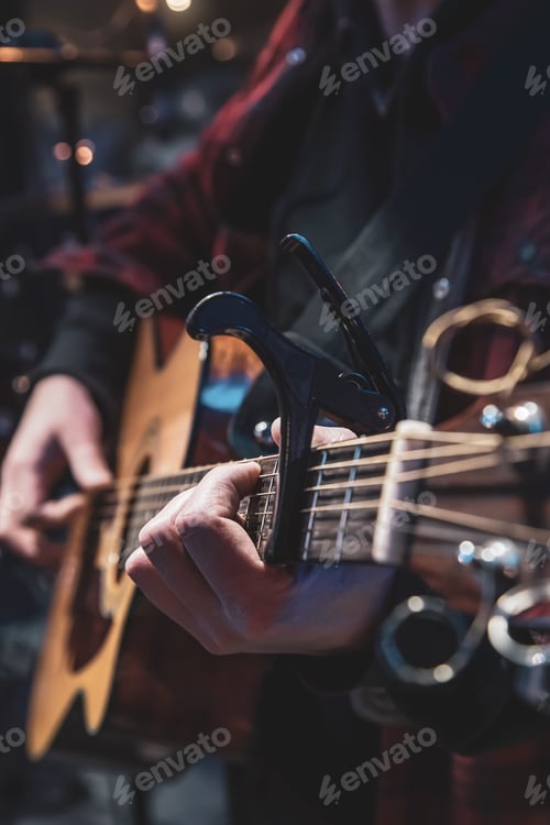 Preview: Guitarist playing acoustic guitar in the dark close up.