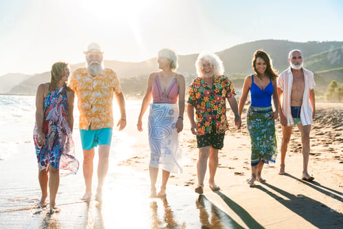 Preview: Happy group of senior friends bonding at the beach during summertime