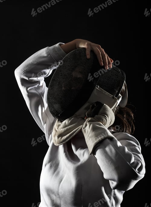 Preview: Portrait of woman wearing white fencing costume practicing with the sword.