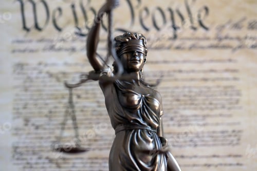 Preview: Lady Justice bronze statue and US Constitution blurred page close up. Lawsuit and justice in US