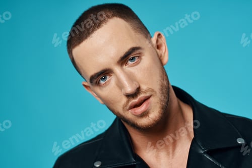 Preview: handsome man short haired leather jacket close-up blue background