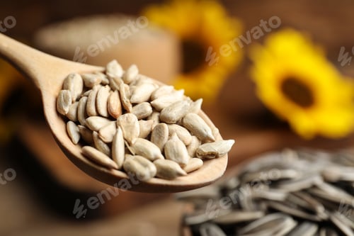 Preview: Wooden spoon with raw peeled sunflower seeds, closeup