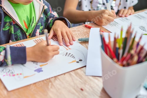 Preview: Child drawing with colors on wooden table