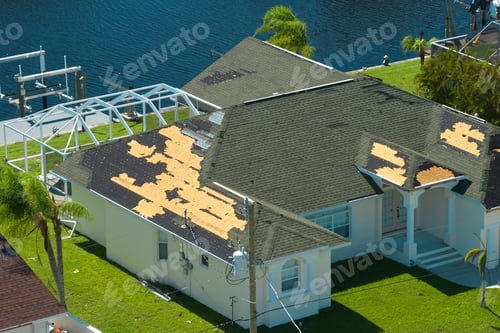 Preview: Damaged house roof with missing shingles after hurricane Ian in Florida.