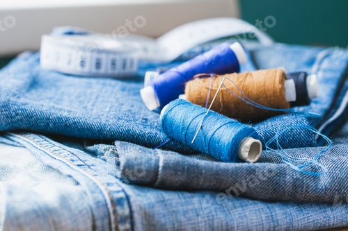 Preview: Handicraft, repair tailoring. Sewing accessories threads close-up denim wooden table