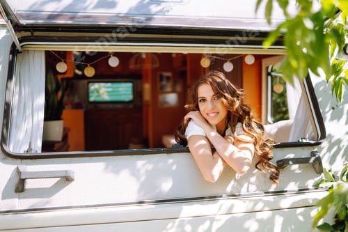 Preview: Beautiful stylish bride near trailer. Camping season. Marriage. Happy newlywed woman.