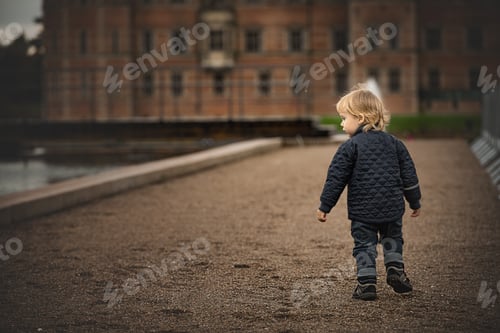 Preview: Blond boy going to building, from back