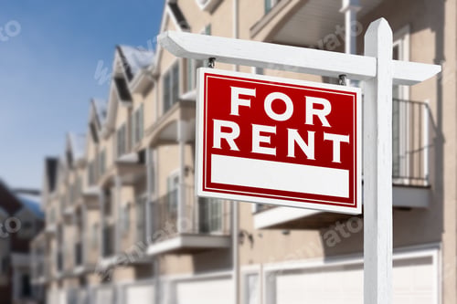 Preview: For Rent Real Estate Sign In Front of a Row of Apartment Condominiums Balconies and Garage Doors.