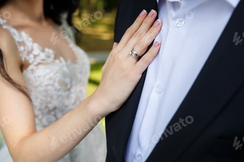 Preview: gold wedding rings in the hands of the newlyweds