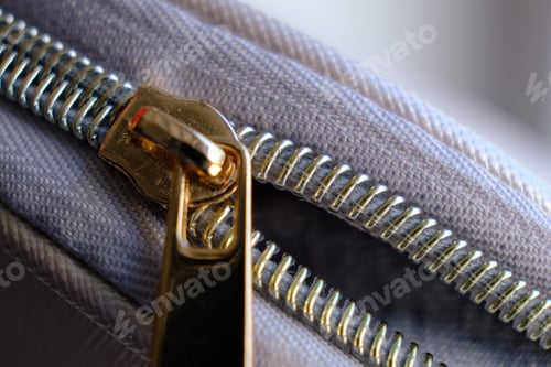 Preview: Selective focus, yellow metal zipper of a makeup bag or small purse macro pattern background