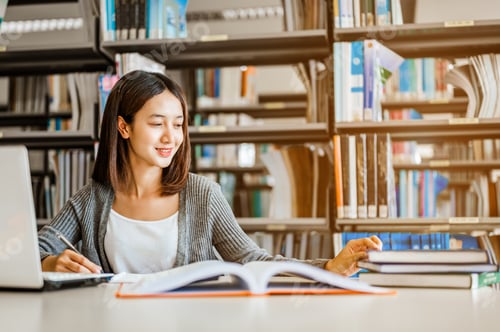 Preview: High school or college students studying and reading together in library. Student use laptop at libr