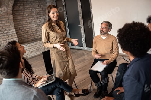 Preview: Group of diverse group of business people having a meeting while sitting in circle.