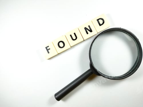 Preview: Magnifying glass and scrabble letters with text FOUND on white background.