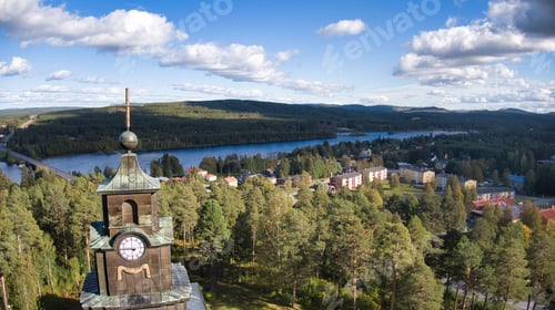 Preview: Aerial view of a clock tower in a picturesque wooded area, surrounded by lush foliage