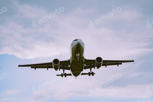 Preview: Low angle shot of an airplane flying in a cloudy sky