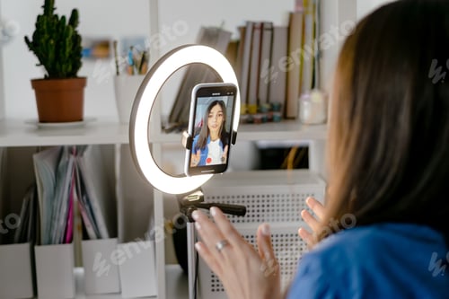 Preview: Girl blogger influencer talking smartphone live recording video blog on social network at home.