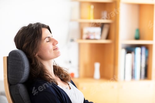 Preview: Young woman sitting at home, enjoying the moment