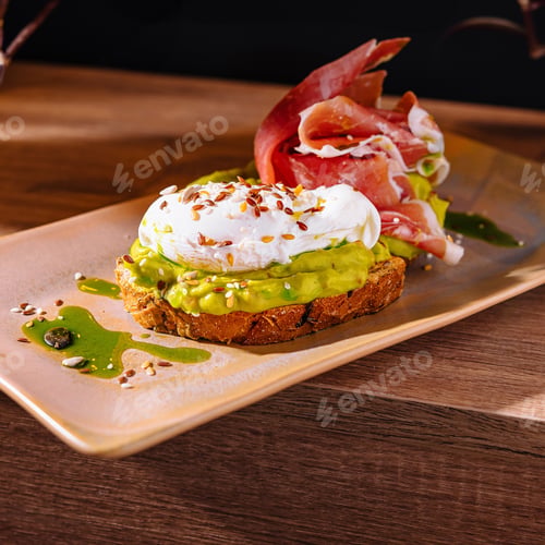 Preview: Delicious toast with avocado spread, poached egg and prosciutto on wooden table