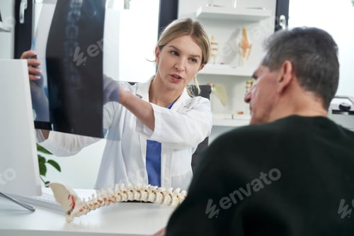 Preview: Caucasian female doctor analyzing with patient disease of spine