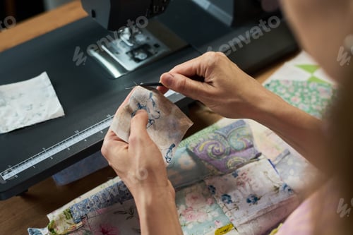 Preview: Caucasian Young Adult Woman Sewing Fabric Pieces with Sewing Machine Indoors