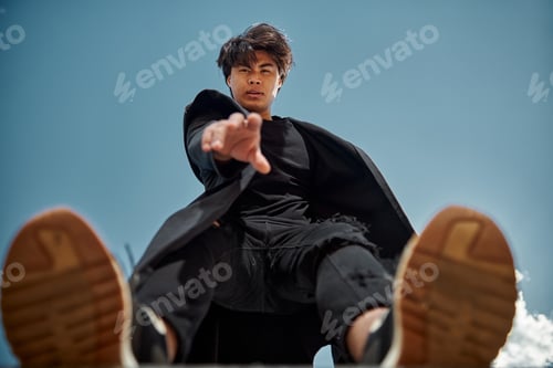 Preview: Handsome young man standing under blue sky