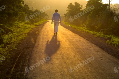 Preview: Young man walking on forest road on sunrise