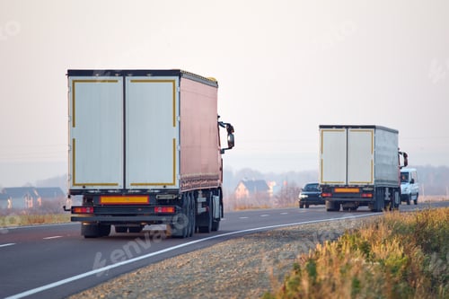Preview: Semi-truck with cargo trailer driving on highway hauling goods in evening.